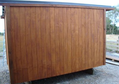 Side elevation of an OutaSpace cabin finished in stained cedar weatherboard