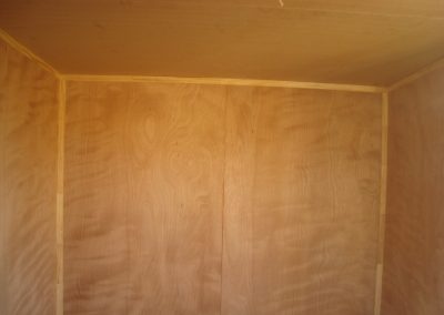 Unfurnished cabin interior lined in plywood