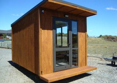 OutaSpace cabin with double glass doors and a timber step, ready for delivery