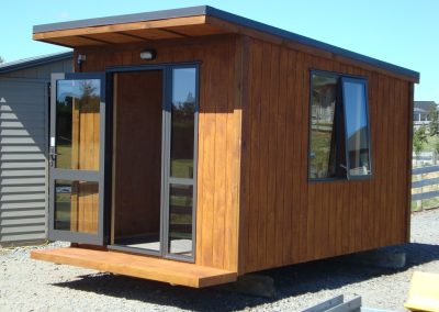 OutaSpace cabin with its double glass doors open, alongside a side window