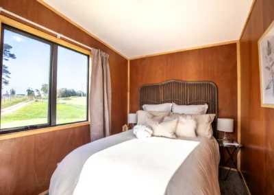 OutaSpace cabin furnished as a bedroom, with a double bed beside a large window