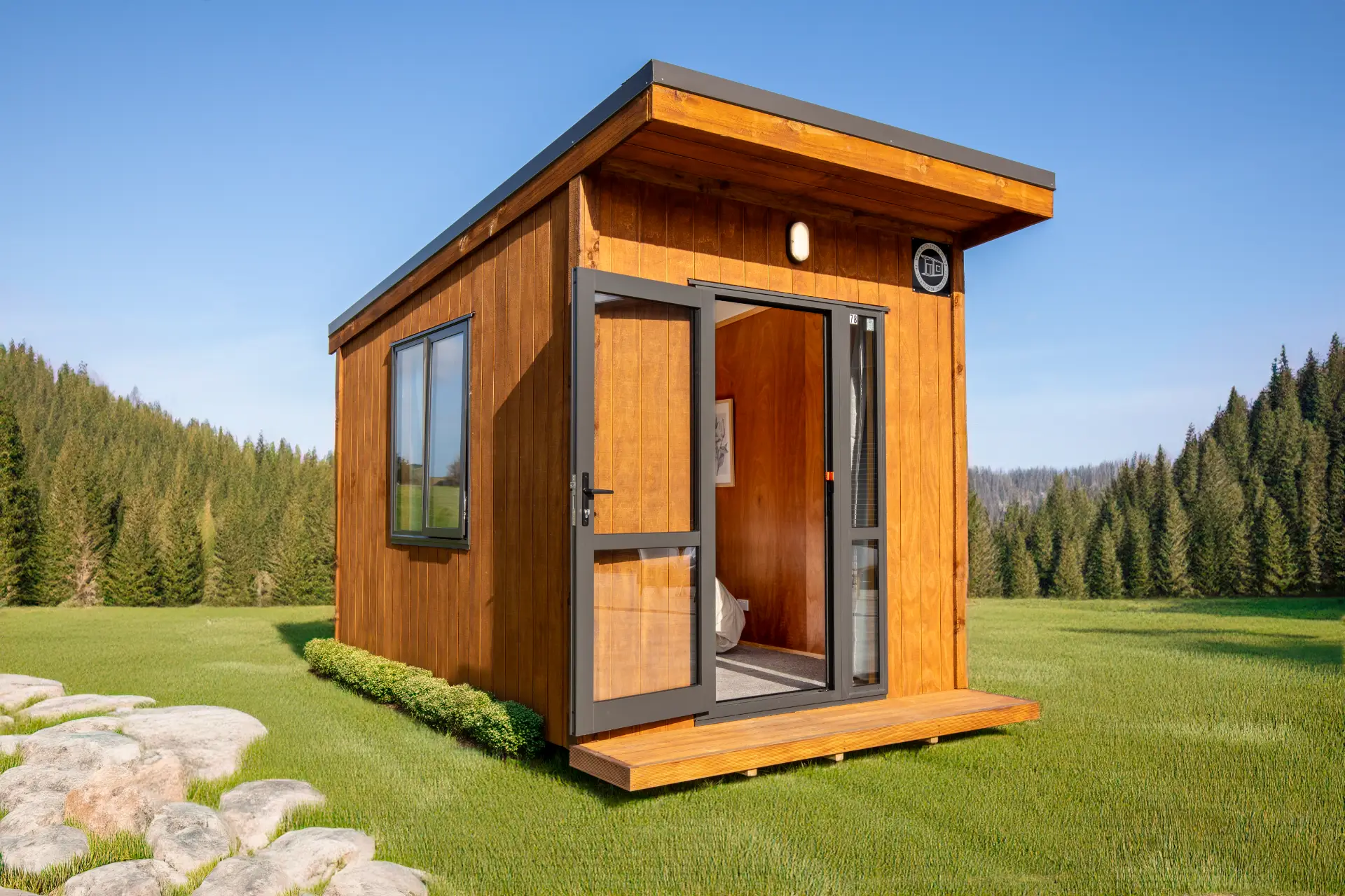 Outaspace 2 Exterior of an OutaSpace cabin with mono-pitch roof, timber deck and glass door open to the bedroom