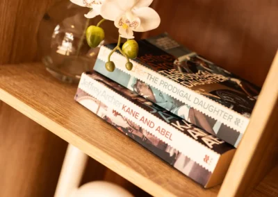Books and an orchid arranged on the desk inside a cabin