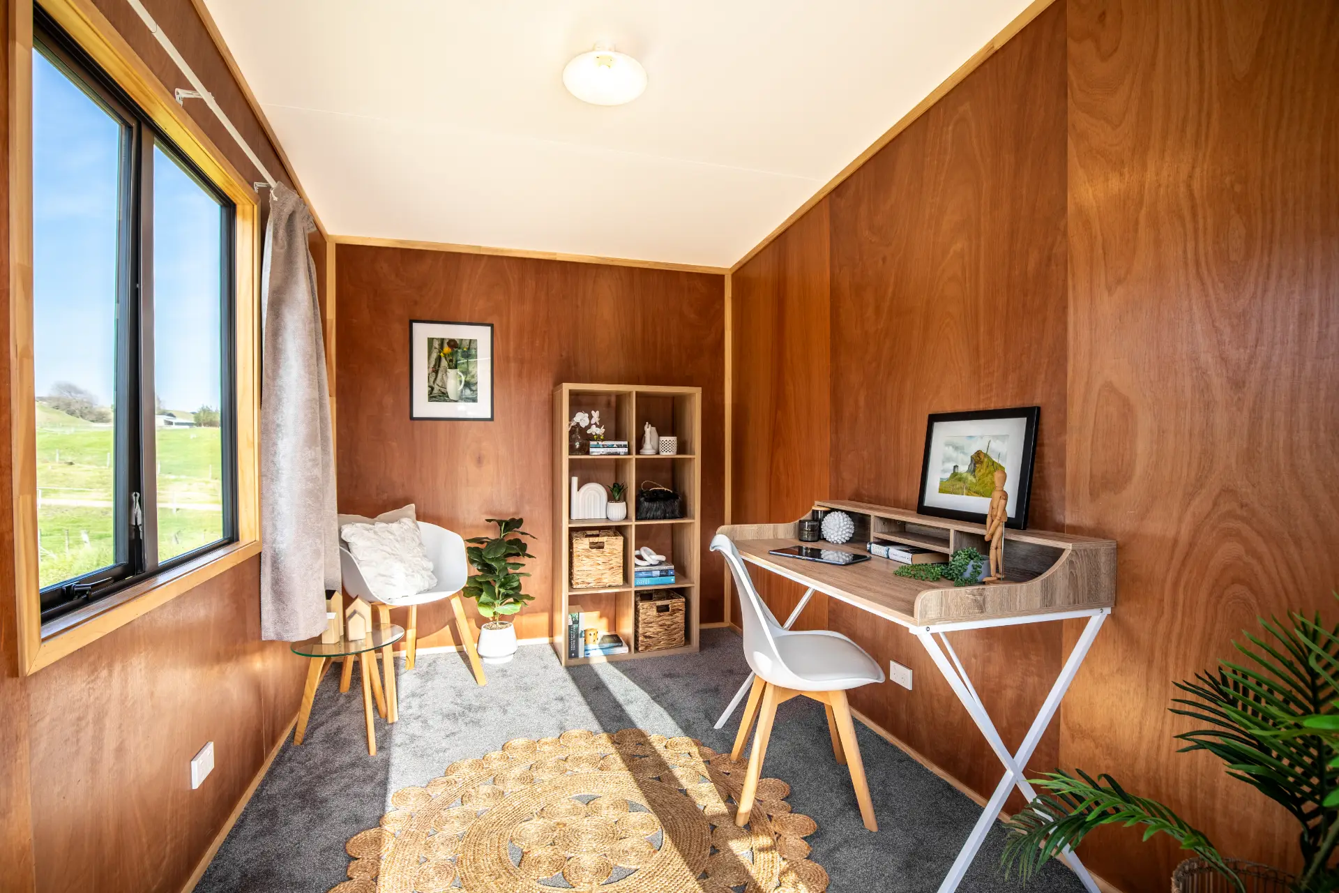 Outaspace 9 Cabin interior furnished as a home office, with a desk, chair and window looking out over paddocks